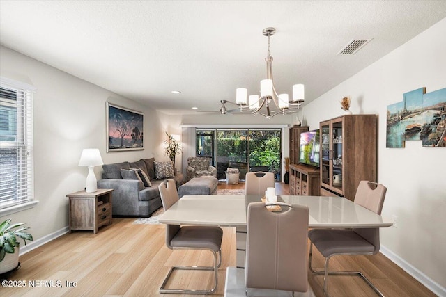 dining area featuring light hardwood / wood-style flooring and a chandelier