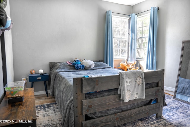 bedroom with wood finished floors and baseboards