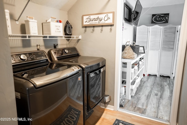 washroom with hardwood / wood-style floors and independent washer and dryer