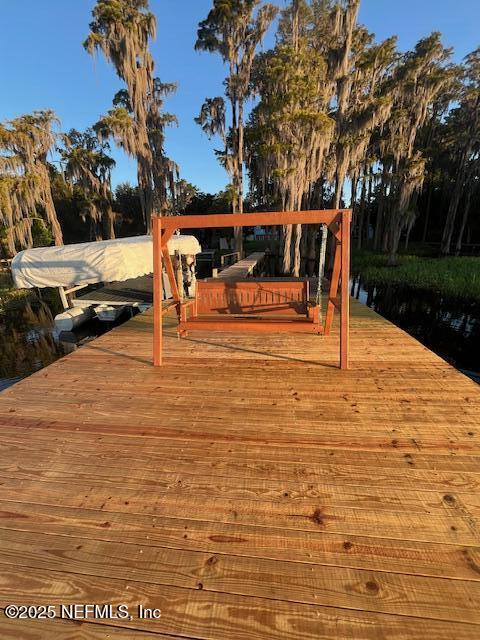 wooden terrace featuring a boat dock and a water view