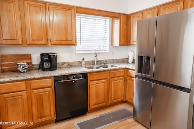 kitchen with sink, black dishwasher, stainless steel fridge with ice dispenser, light stone counters, and light wood-type flooring