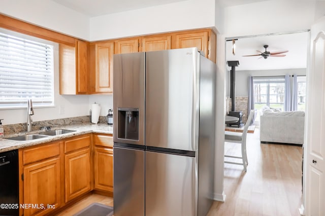 kitchen featuring ceiling fan, sink, dishwasher, stainless steel fridge with ice dispenser, and light hardwood / wood-style floors