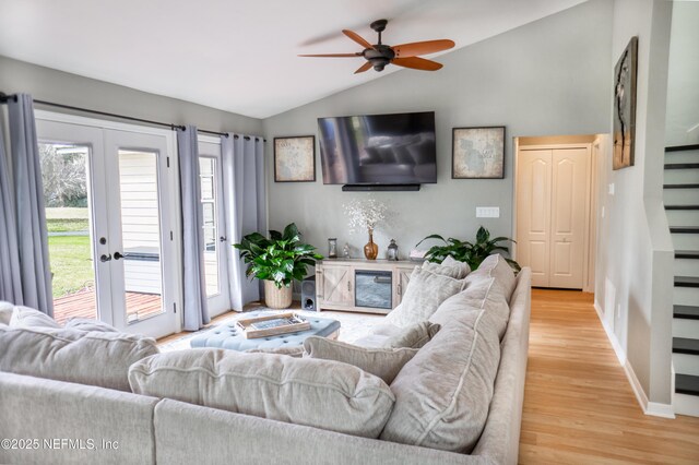 living room with french doors, vaulted ceiling, ceiling fan, and wood-type flooring