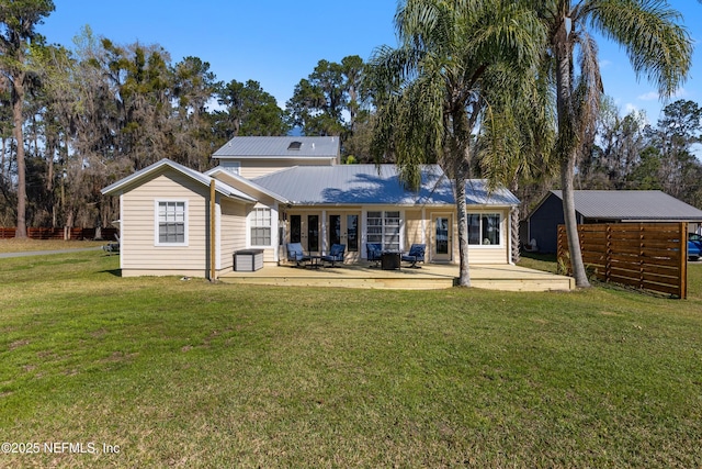 rear view of property with a yard and metal roof