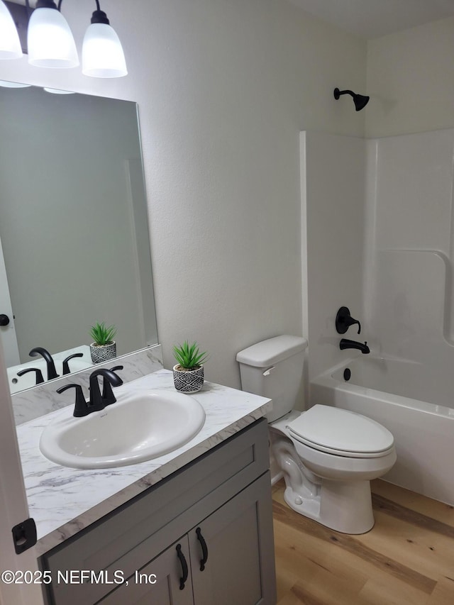 full bathroom with vanity, wood-type flooring, shower / bathtub combination, and toilet