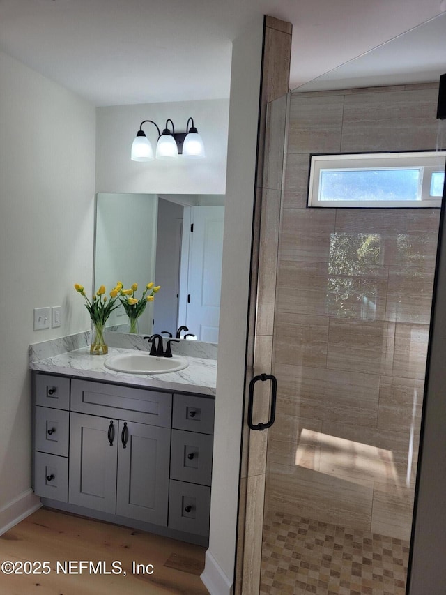 bathroom with vanity, an enclosed shower, and wood-type flooring