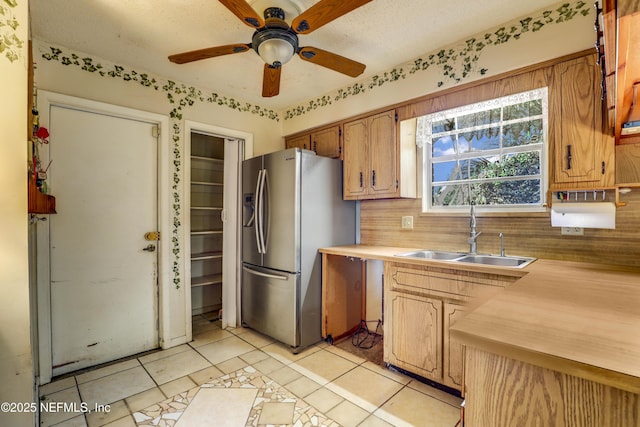 kitchen with stainless steel refrigerator with ice dispenser, tasteful backsplash, ceiling fan, sink, and light tile patterned floors