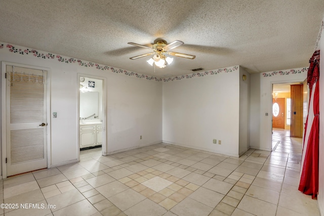 spare room with ceiling fan and a textured ceiling