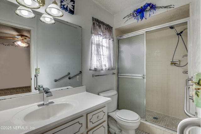 bathroom featuring ceiling fan, vanity, an enclosed shower, and toilet