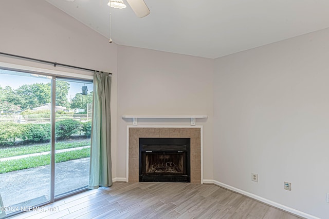 unfurnished living room with ceiling fan, light hardwood / wood-style floors, and a fireplace