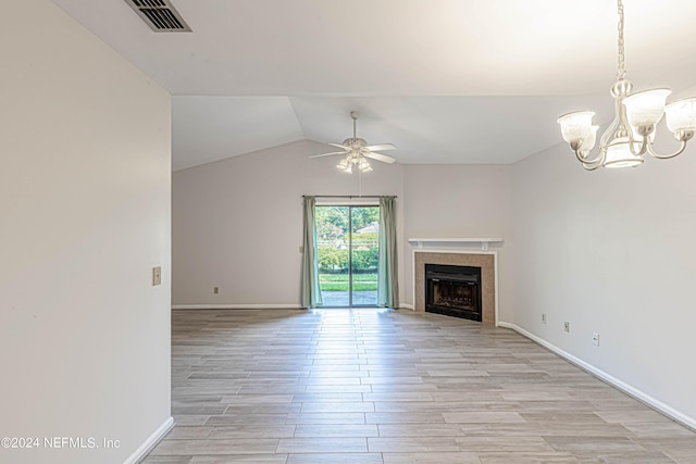 unfurnished living room featuring ceiling fan with notable chandelier, light hardwood / wood-style floors, and vaulted ceiling