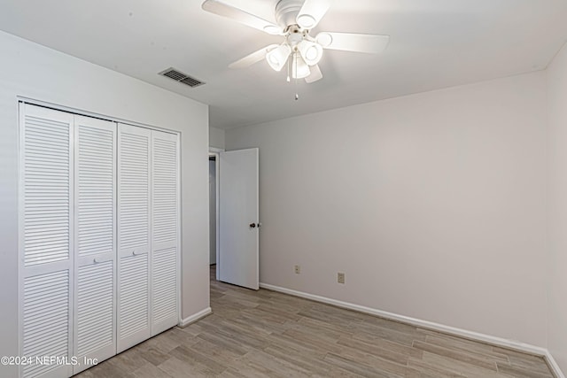 unfurnished bedroom with ceiling fan, light hardwood / wood-style flooring, and a closet