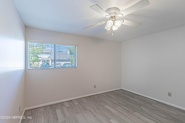 spare room with ceiling fan and light wood-type flooring