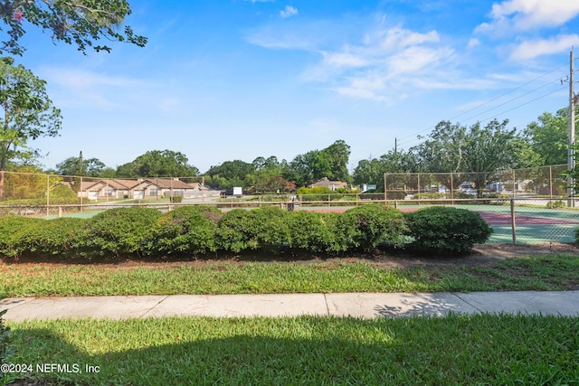 view of home's community with tennis court