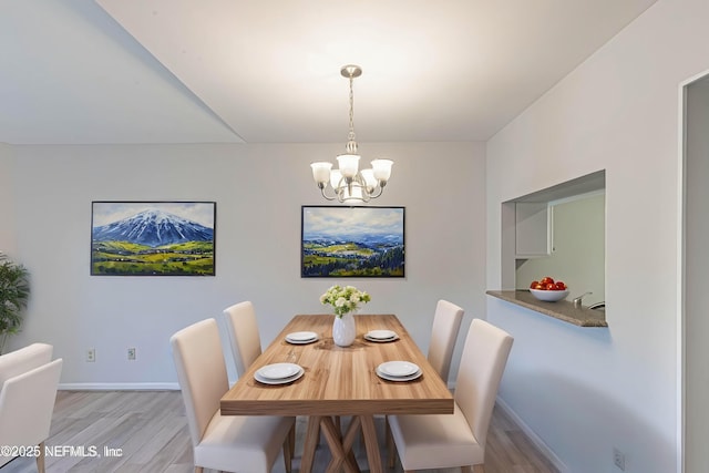 dining space featuring an inviting chandelier and light wood-type flooring