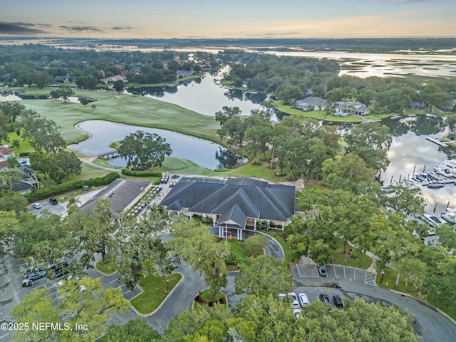 aerial view at dusk featuring a water view