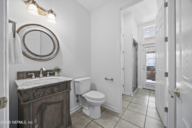 bathroom featuring toilet, a textured ceiling, vanity, and tile patterned floors