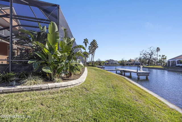 view of dock with a yard, a water view, and a lanai