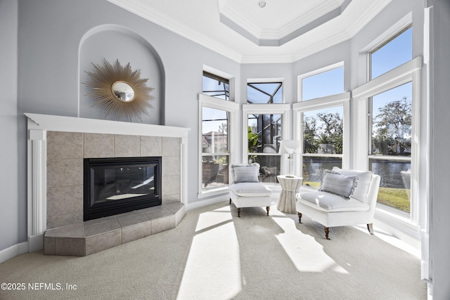 living room with a tile fireplace, carpet floors, a water view, and a wealth of natural light