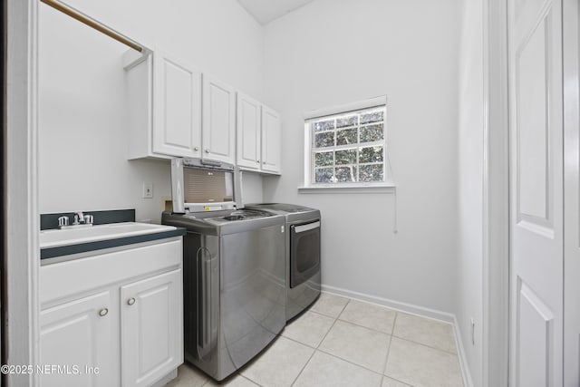 washroom featuring separate washer and dryer, sink, light tile patterned flooring, and cabinets