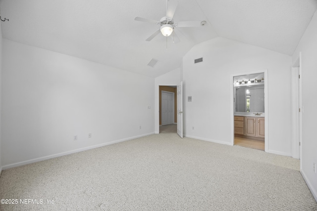 unfurnished bedroom with ensuite bathroom, sink, vaulted ceiling, ceiling fan, and light colored carpet