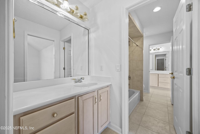 bathroom featuring tile patterned flooring, vanity, and tiled shower / bath