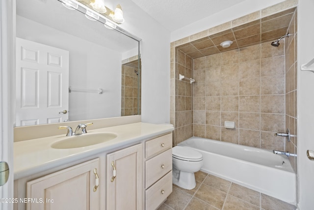 full bathroom featuring tiled shower / bath, vanity, a textured ceiling, and toilet