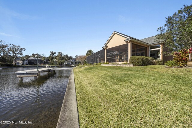 view of dock featuring a lawn and a water view