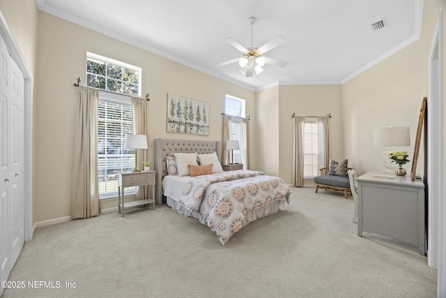 carpeted bedroom with ceiling fan, a closet, and crown molding