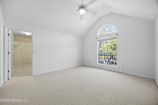 interior space with ceiling fan, light colored carpet, and lofted ceiling