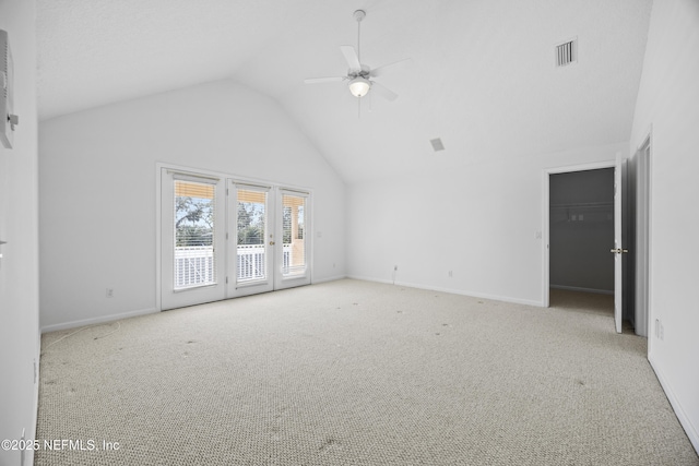 unfurnished living room featuring ceiling fan, light colored carpet, and vaulted ceiling