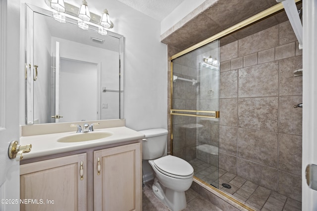 bathroom with a textured ceiling, vanity, toilet, and walk in shower