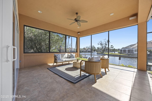 sunroom / solarium featuring a water view and ceiling fan