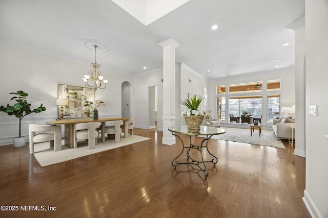 dining area with a chandelier, dark hardwood / wood-style flooring, ornate columns, and ornamental molding