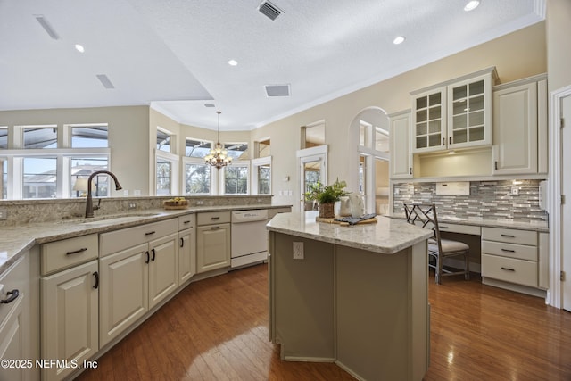 kitchen featuring tasteful backsplash, sink, dishwasher, a kitchen island, and hanging light fixtures