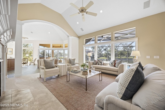 living room with a wealth of natural light, light colored carpet, high vaulted ceiling, and ceiling fan