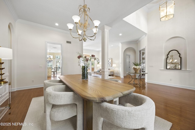 dining area featuring ornamental molding, dark wood-type flooring, and decorative columns