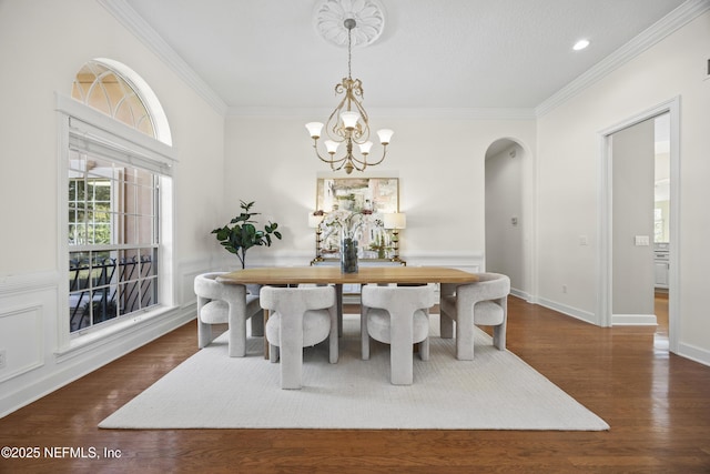 dining area with crown molding, dark hardwood / wood-style flooring, and a notable chandelier