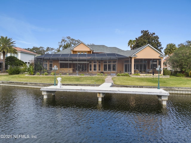 rear view of house with a yard, a water view, and glass enclosure