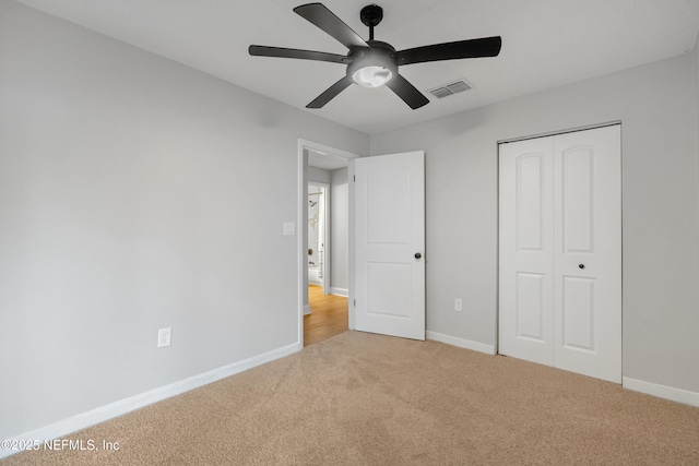 unfurnished bedroom featuring carpet, a closet, and ceiling fan