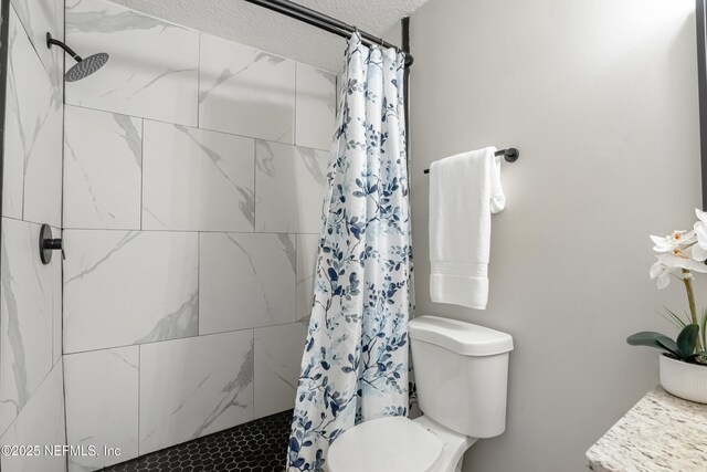 bathroom with a textured ceiling, toilet, and walk in shower