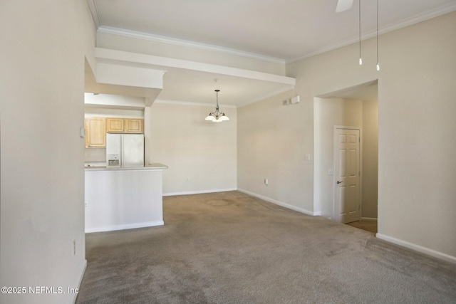 spare room featuring carpet floors, ornamental molding, and an inviting chandelier