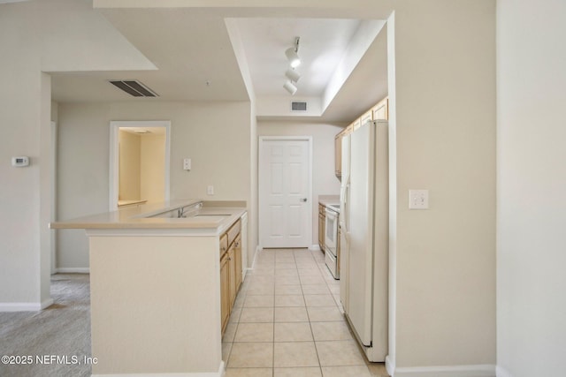 kitchen with sink, white appliances, light tile patterned floors, kitchen peninsula, and light brown cabinetry