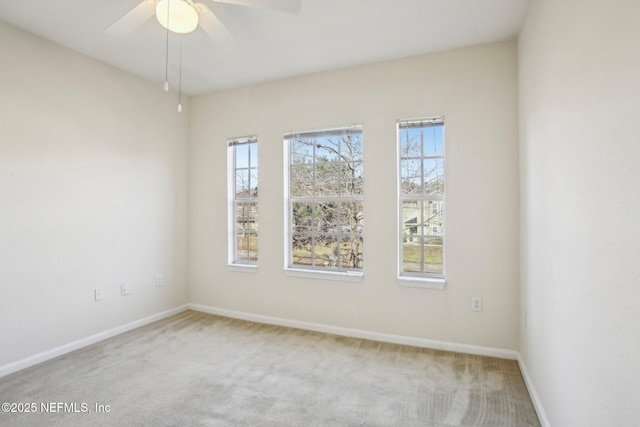 carpeted spare room featuring ceiling fan