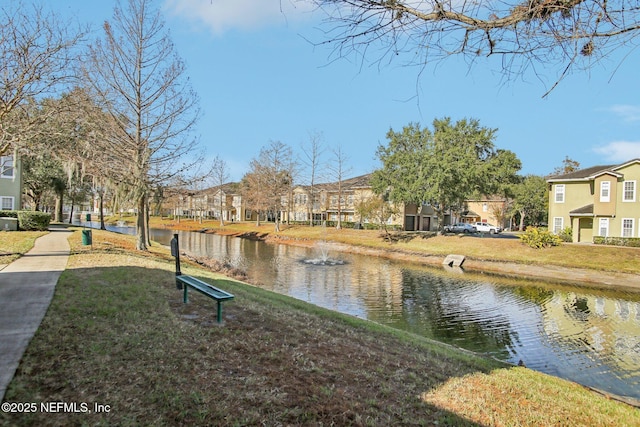 view of property's community with a yard and a water view