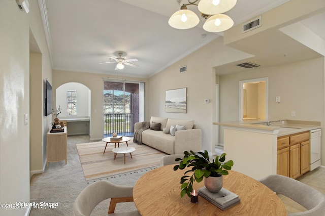 dining space featuring sink, lofted ceiling, light carpet, ornamental molding, and ceiling fan with notable chandelier