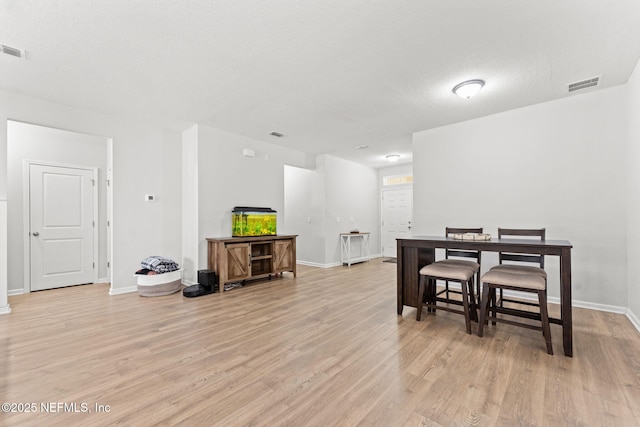 dining room featuring a textured ceiling and light hardwood / wood-style floors