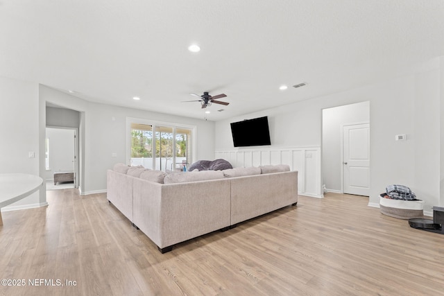 living room featuring ceiling fan and light hardwood / wood-style floors