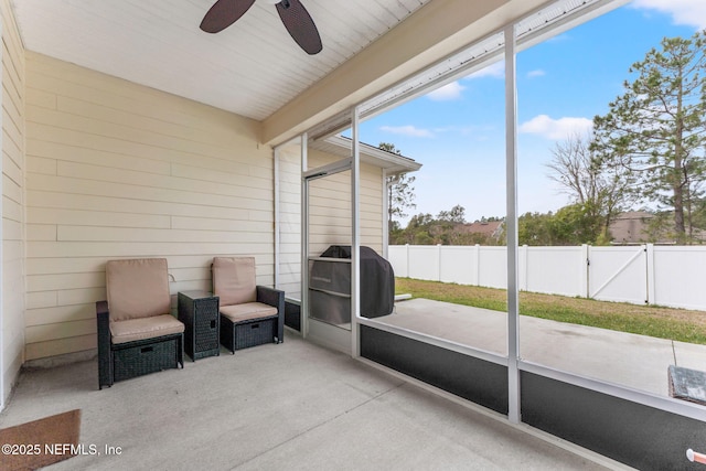 unfurnished sunroom with ceiling fan