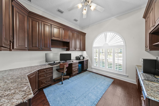 office featuring ceiling fan, dark hardwood / wood-style floors, a textured ceiling, built in desk, and ornamental molding